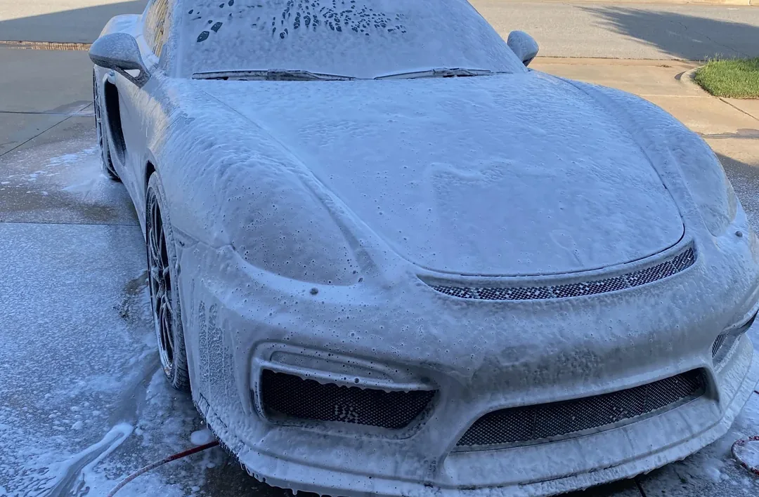 A car covered in wash foam during an exterior detail