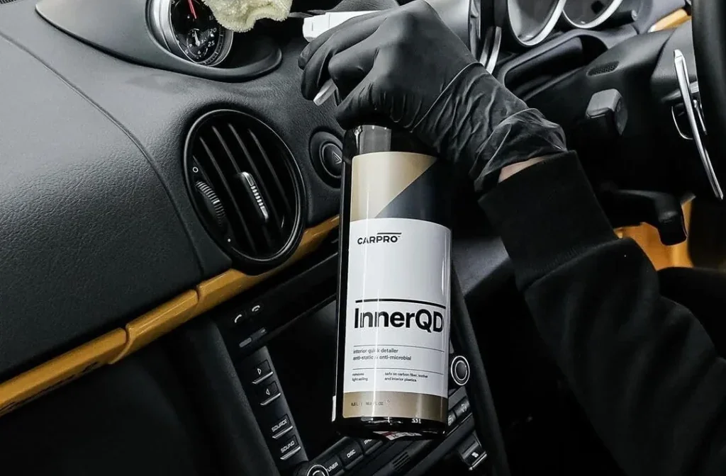 Interior detailer being sprayed onto a dashboard